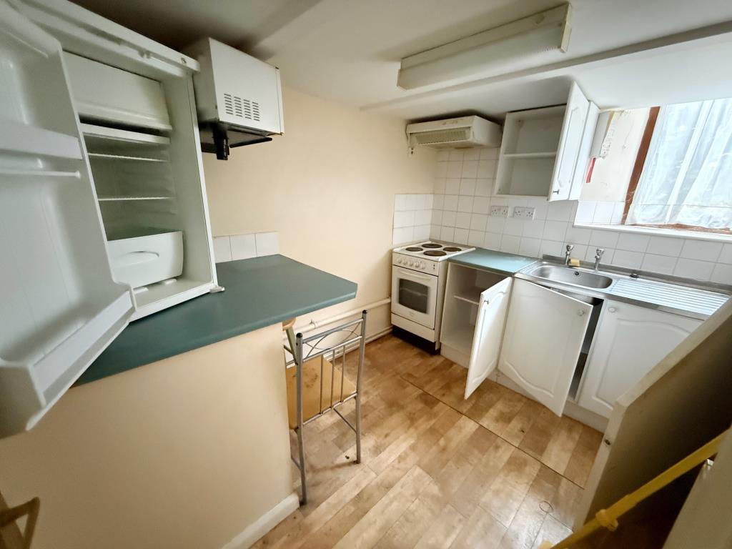 Lot: 5 - FORMER OFFICE AND BEDSITS WITH POTENTIAL CLOSE TO THE QUAY - Kitchen area in self-contained bedsit 1